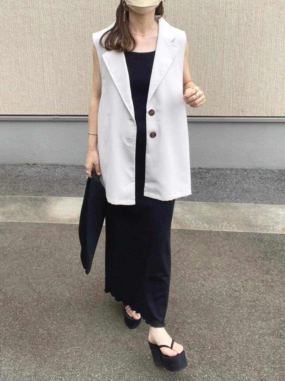 ベージュ系のベスト、ブラック系のワンピース、ブラック系のトートバッグを着用したレディースの夏コーディネートの4枚目の写真