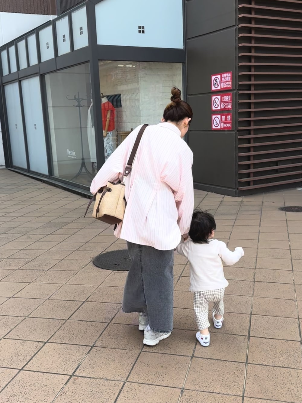 ピンク系のシャツ/ブラウス、ブラック系のデニムスカート、ブラウン系のトートバッグを着用したレディースの春コーディネートの4枚目の写真