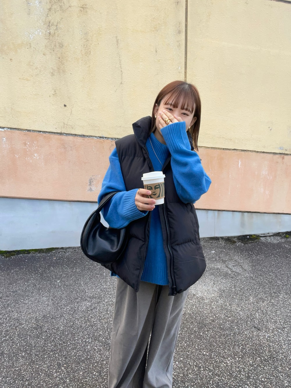 ブルー系のニット/セーター、ブラック系のベスト、ブラウン系のパンツを着用したレディースの秋コーディネートの5枚目の写真