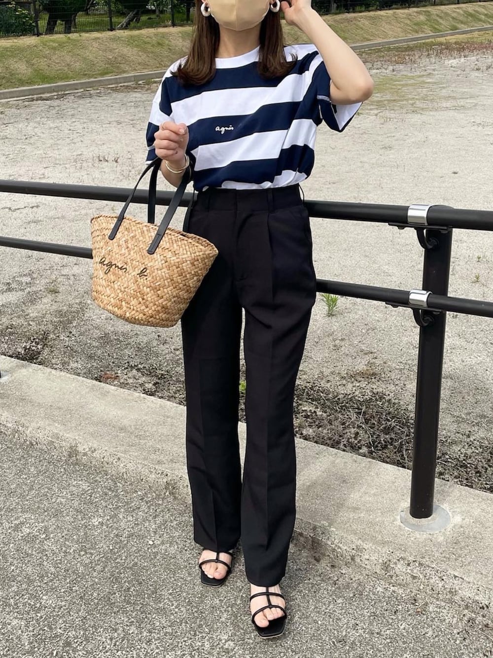 ブルー系のTシャツ/カットソー、ブラック系のスラックス、ブラック系のかごバッグを着用したレディースの夏コーディネートの2枚目の写真