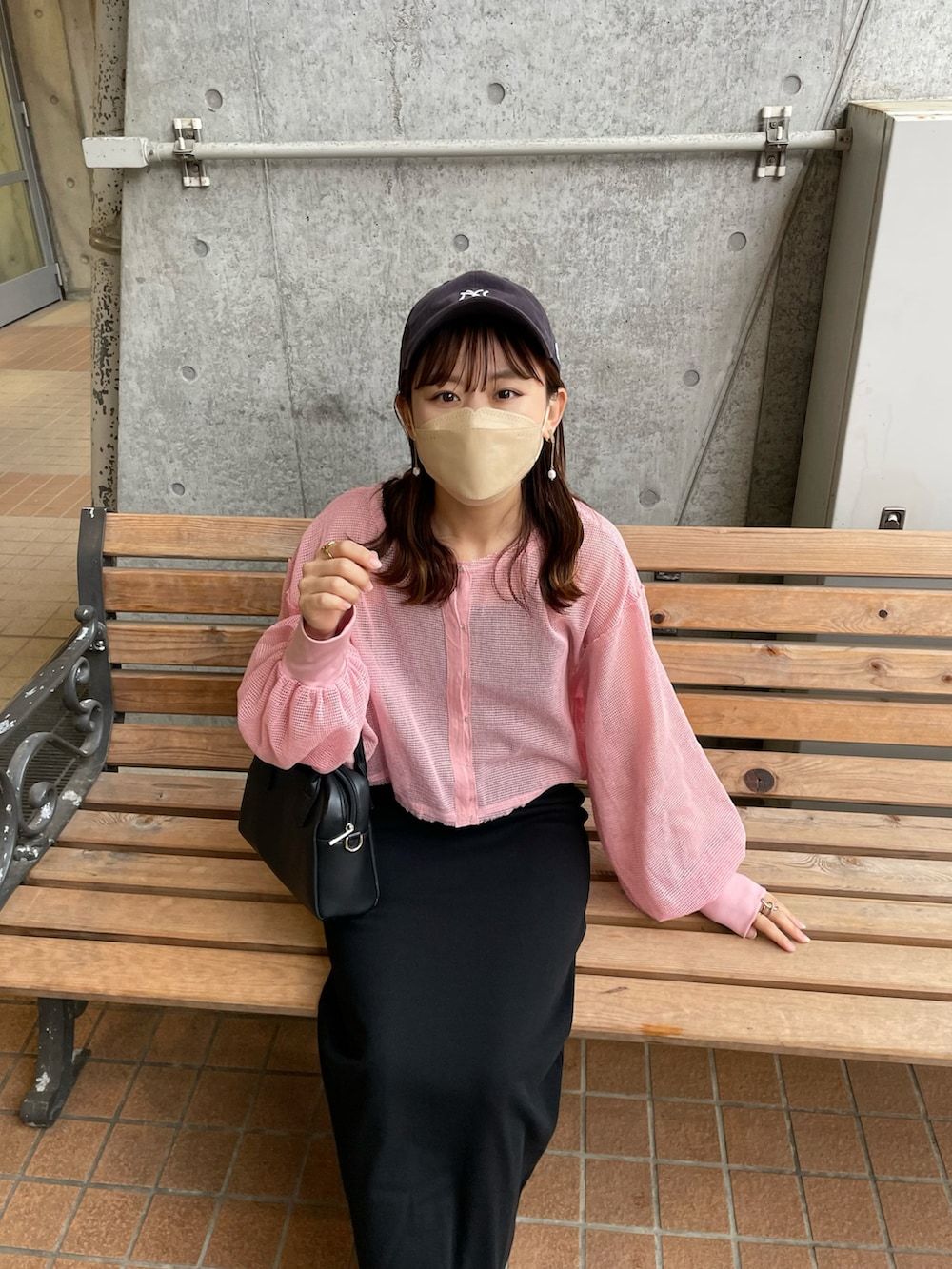 ピンク系のカーディガン/ボレロ、ブラック系のワンピース、ホワイト系のスニーカーを着用したレディースの春コーディネートの4枚目の写真