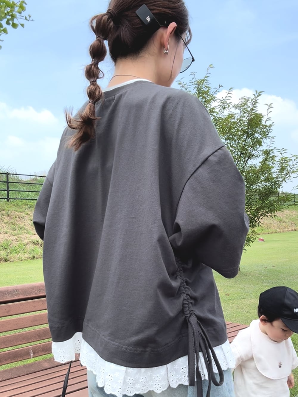 グレー系のTシャツ/カットソー、ブルー系のデニムパンツ、ブラック系のスニーカーを着用したレディースの夏コーディネートの2枚目の写真