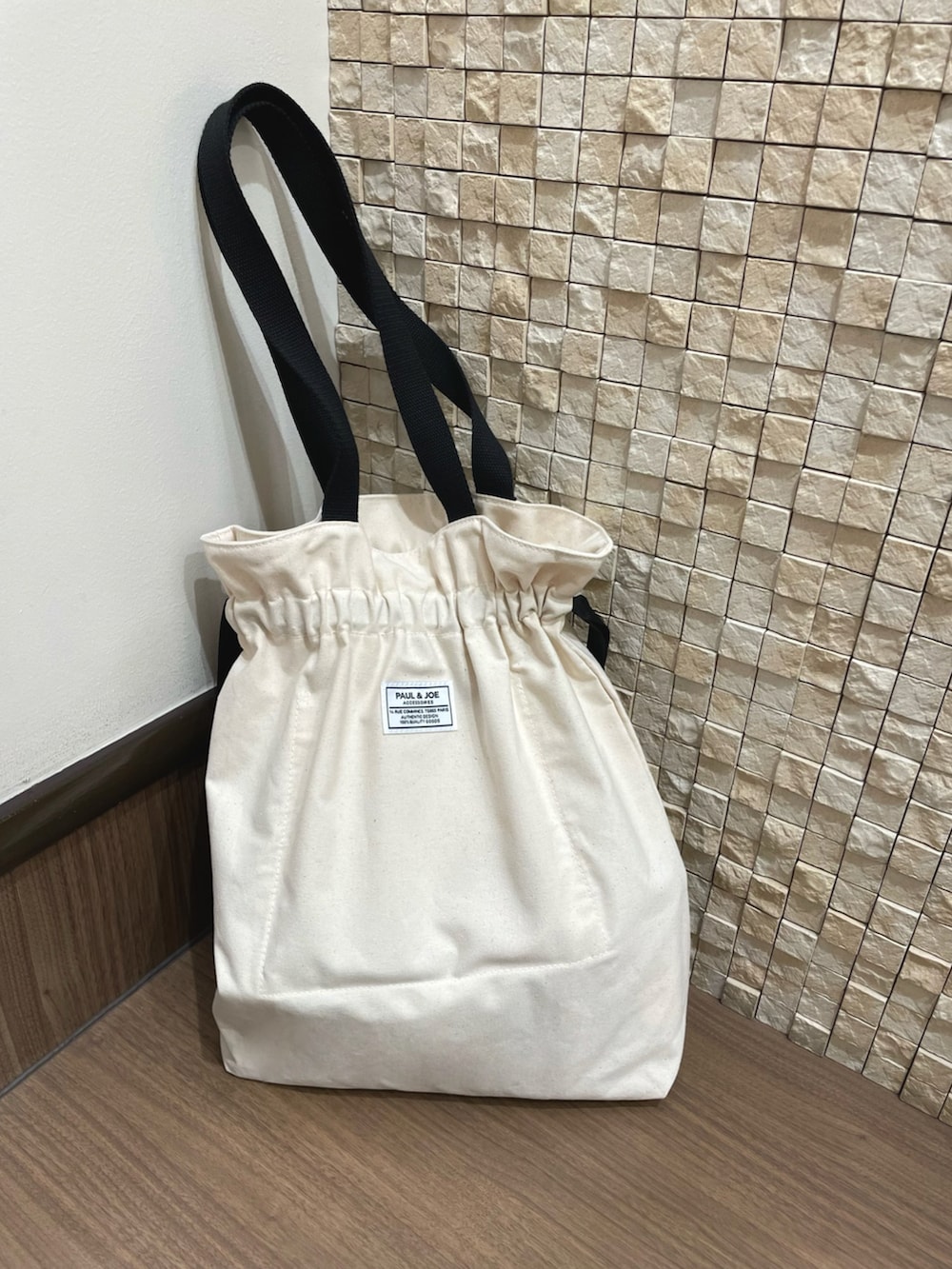 ブラック系のジャケット/アウター、ホワイト系のトートバッグ、ベージュ系のワンピースを着用したレディースの春コーディネートの4枚目の写真