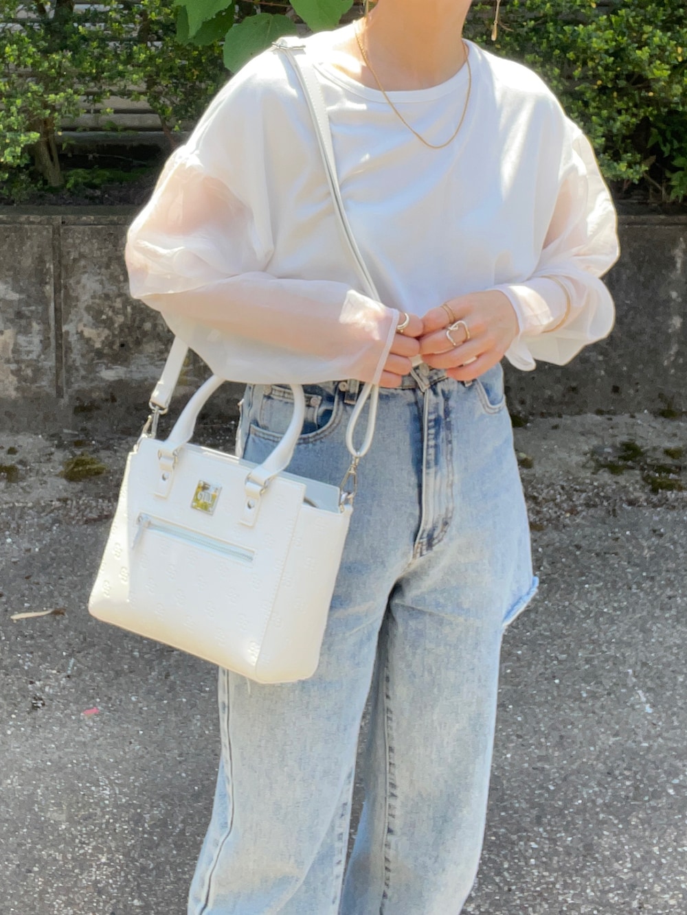 ホワイト系のハンドバッグ、ホワイト系のTシャツ/カットソー、その他のデニムパンツを着用したレディースの春コーディネートの4枚目の写真