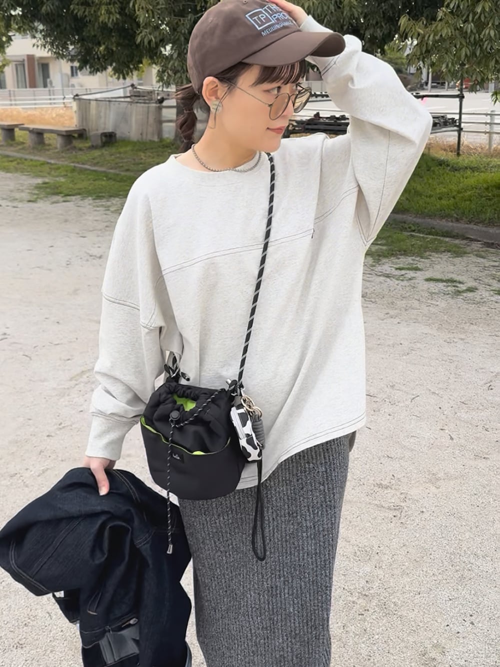 ベージュ系のTシャツ/カットソー、ベージュ系のスニーカー、グレー系のスカートを着用したレディースの春コーディネートの3枚目の写真