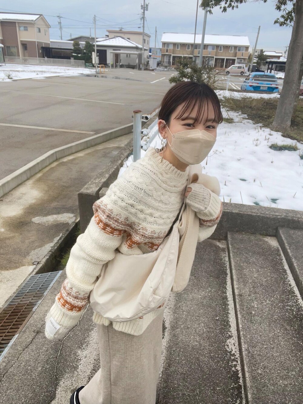 ブラウン系のニット/セーター、ホワイト系のショルダーバッグ、ベージュ系のスカートを着用したレディースの冬コーディネートの4枚目の写真