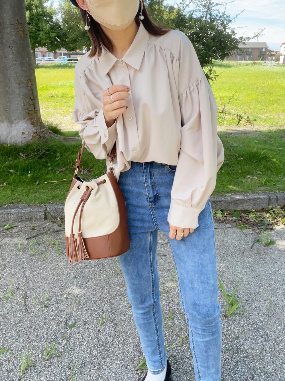 ベージュ系のシャツ/ブラウス、ブルー系のデニムパンツ、ブラック系のローファーを着用したレディースの秋コーディネートの4枚目の写真