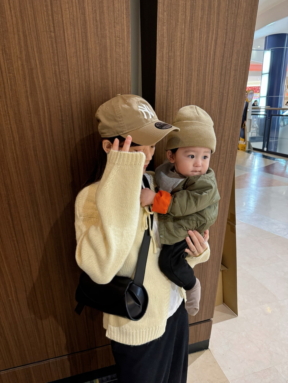 ホワイト系のカーディガン/ボレロ、ブラック系のスカート、ブラック系のショルダーバッグを着用したレディースの冬コーディネートの2枚目の写真