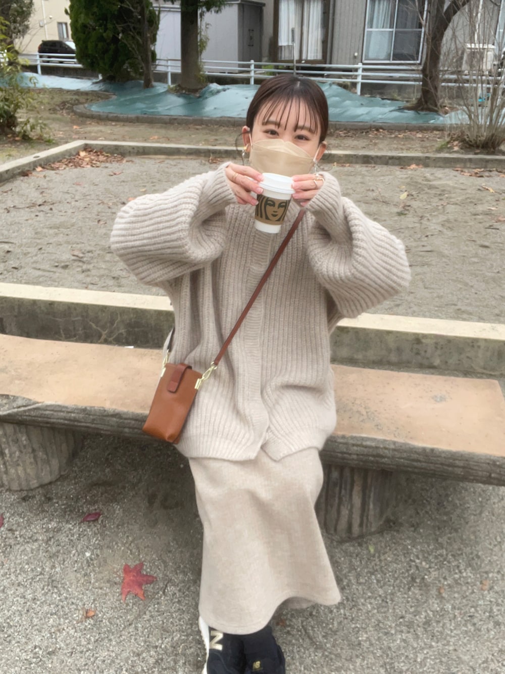ホワイト系のカーディガン/ボレロ、ホワイト系のニット/セーター、ベージュ系のスカートを着用したレディースの冬コーディネートの2枚目の写真