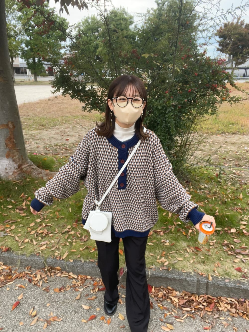 ブルー系のニット/セーター、ホワイト系のTシャツ/カットソー、ホワイト系のショルダーバッグを着用したレディースの秋コーディネートの5枚目の写真