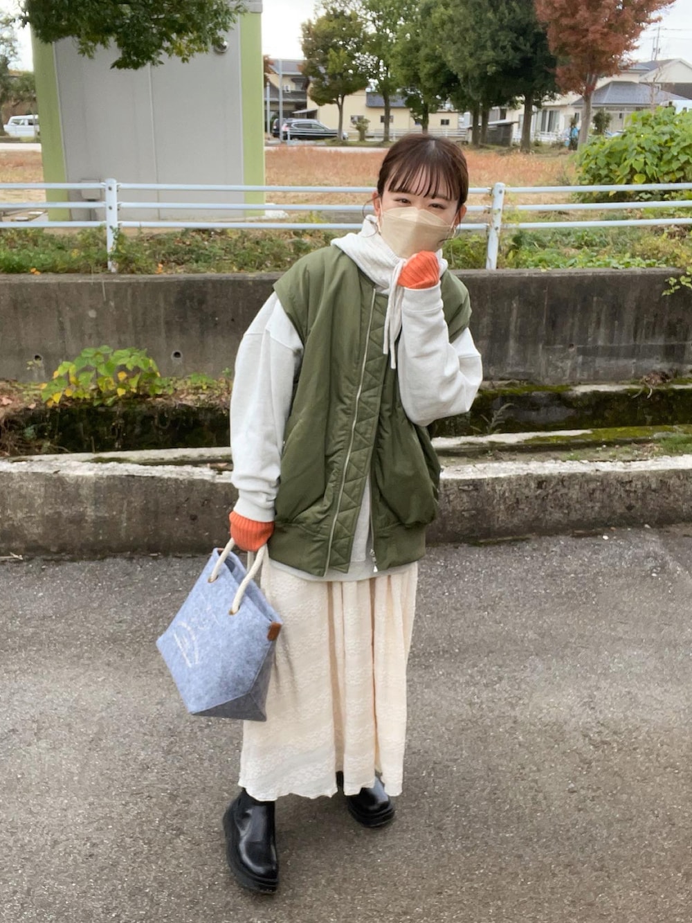 グレー系のトートバッグ、グレー系のスウェット、グリーン系のMA-1を着用したレディースの秋コーディネートの3枚目の写真