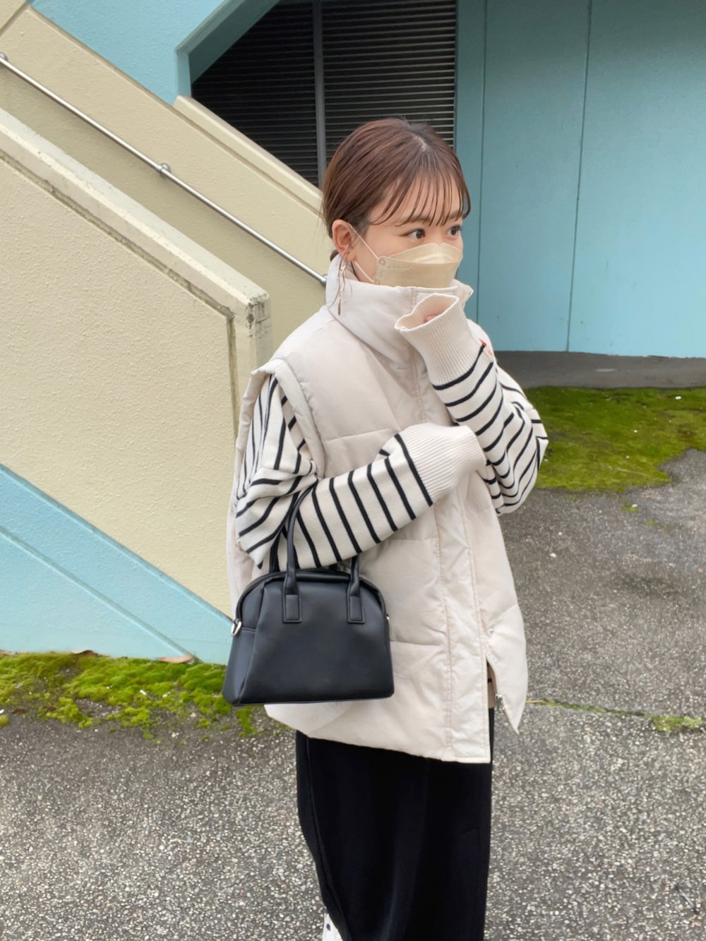 ホワイト系のニット/セーター、ホワイト系のダウンベスト、ブラック系のスカートを着用したレディースの冬コーディネートの3枚目の写真