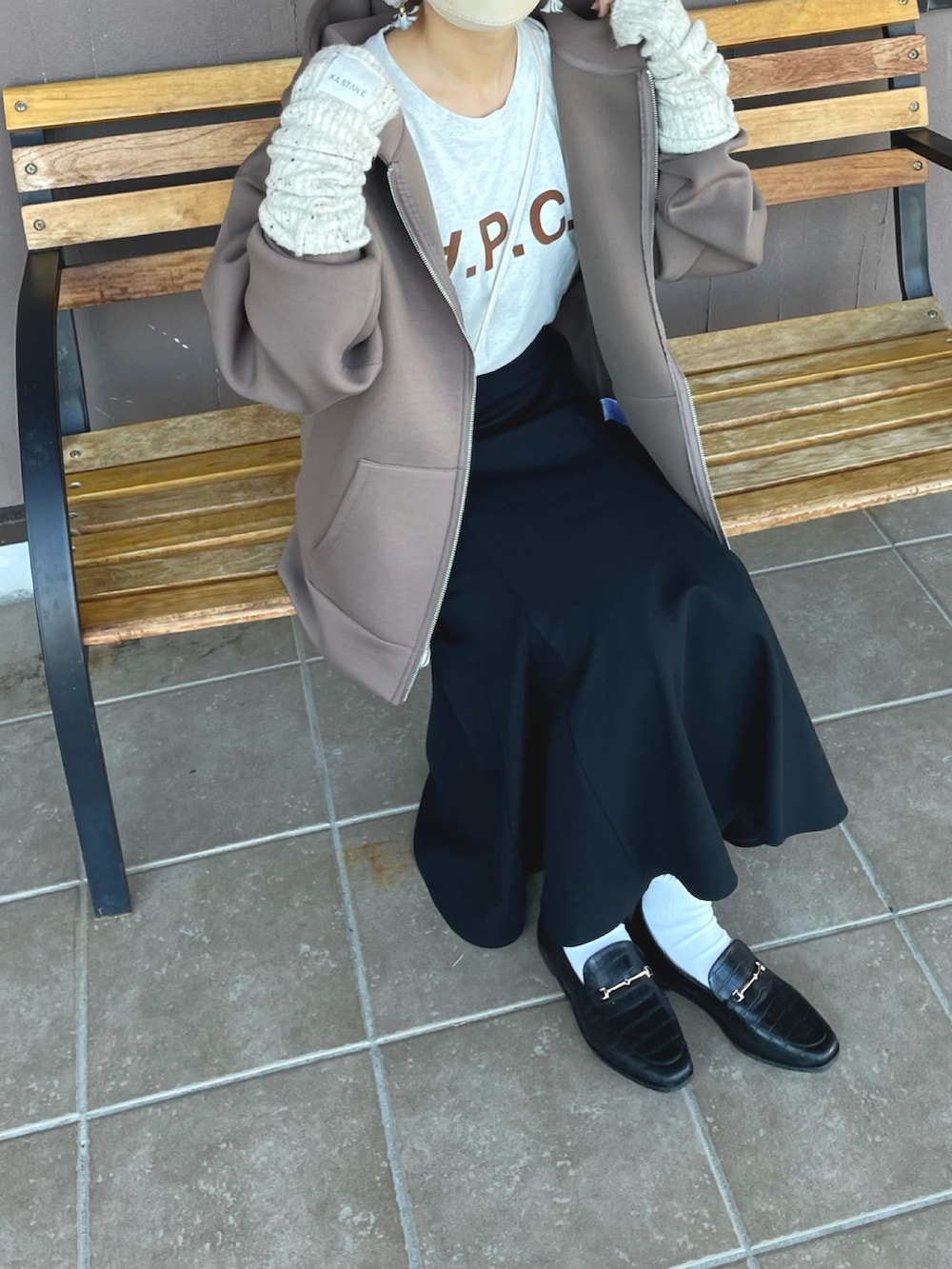 ブラウン系のパーカー、ブラック系のスカート、ホワイト系のTシャツ/カットソーを着用したレディースの秋コーディネートの5枚目の写真