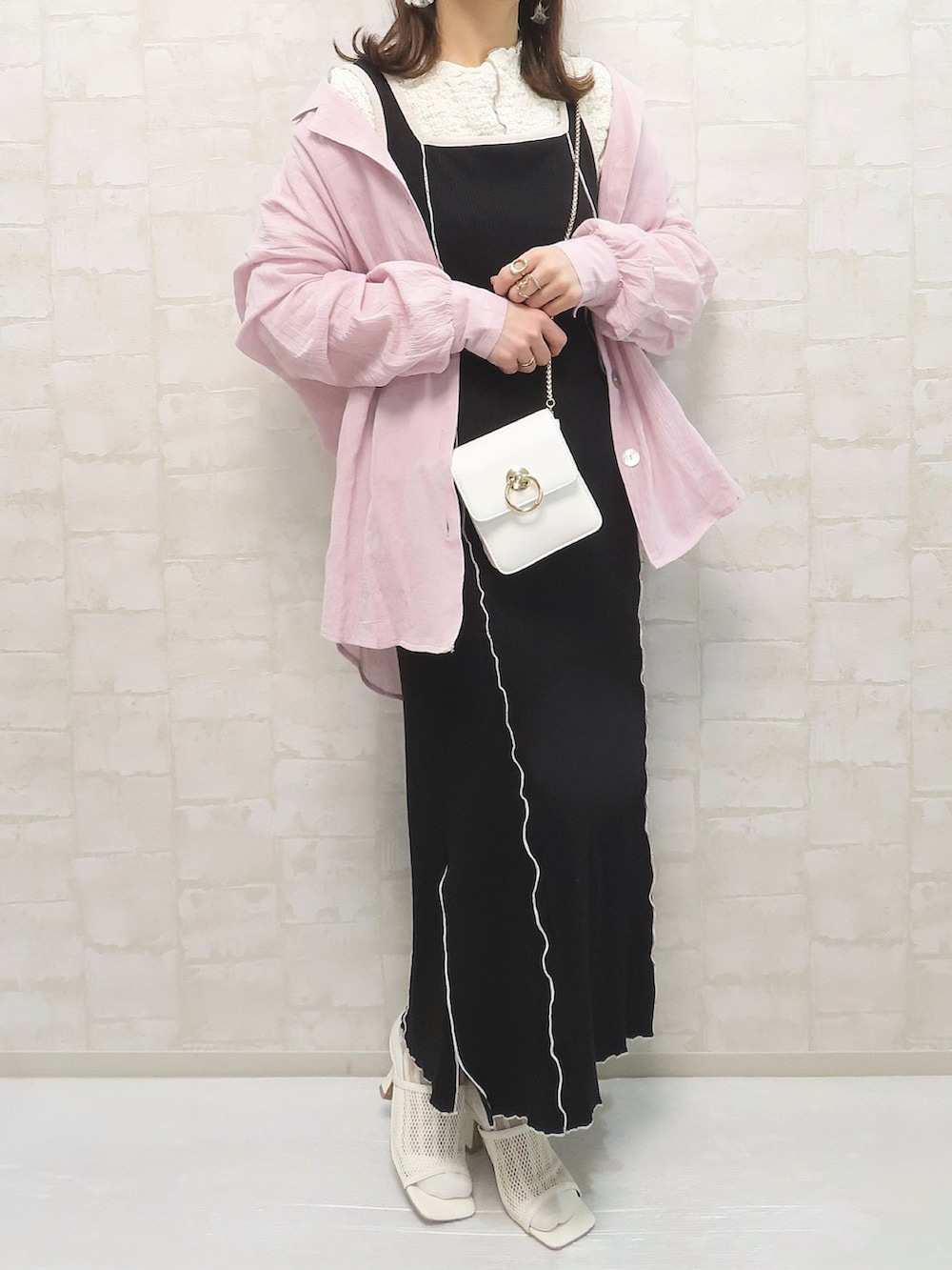 ホワイト系のTシャツ/カットソー、ブラック系のワンピース、ホワイト系のショルダーバッグを着用したレディースの春コーディネートの2枚目の写真