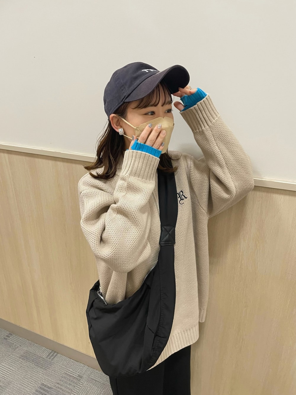 ベージュ系のニット/セーター、ブラック系のスカート、ブラック系のショルダーバッグを着用したレディースの春コーディネートの5枚目の写真