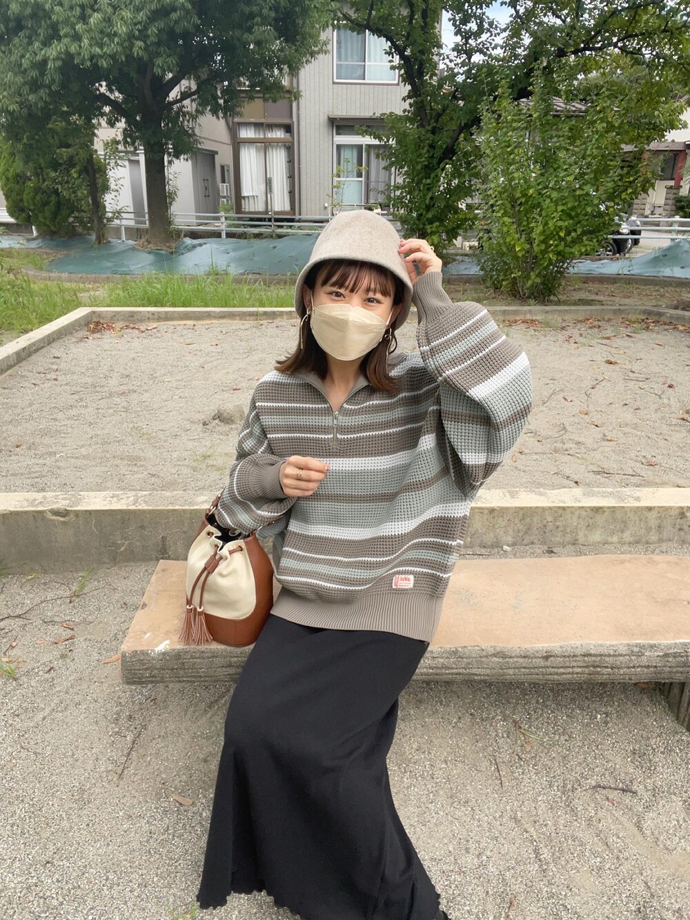 ブルー系のニット/セーター、ブラック系のワンピース、ブラウン系のショルダーバッグを着用したレディースの秋コーディネートの3枚目の写真