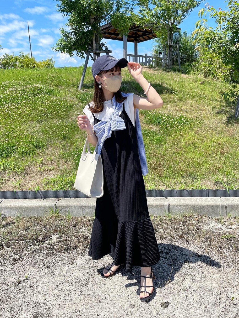 ホワイト系のトートバッグ、ブラック系のワンピース、ホワイト系のニット/セーターを着用したレディースの夏コーディネートの3枚目の写真