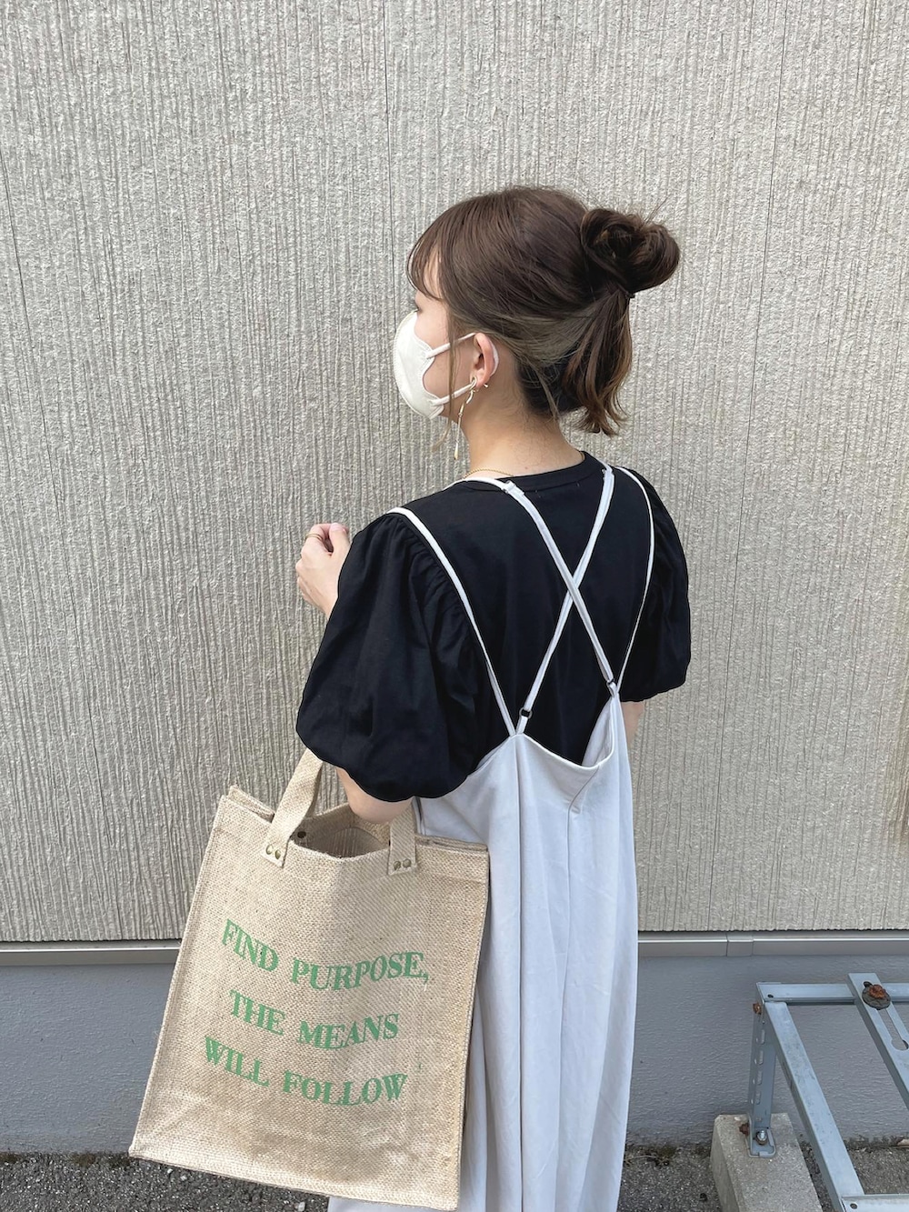 ブラック系のTシャツ/カットソー、ベージュ系のワンピース、グリーン系のバッグを着用したレディースの春コーディネートの2枚目の写真