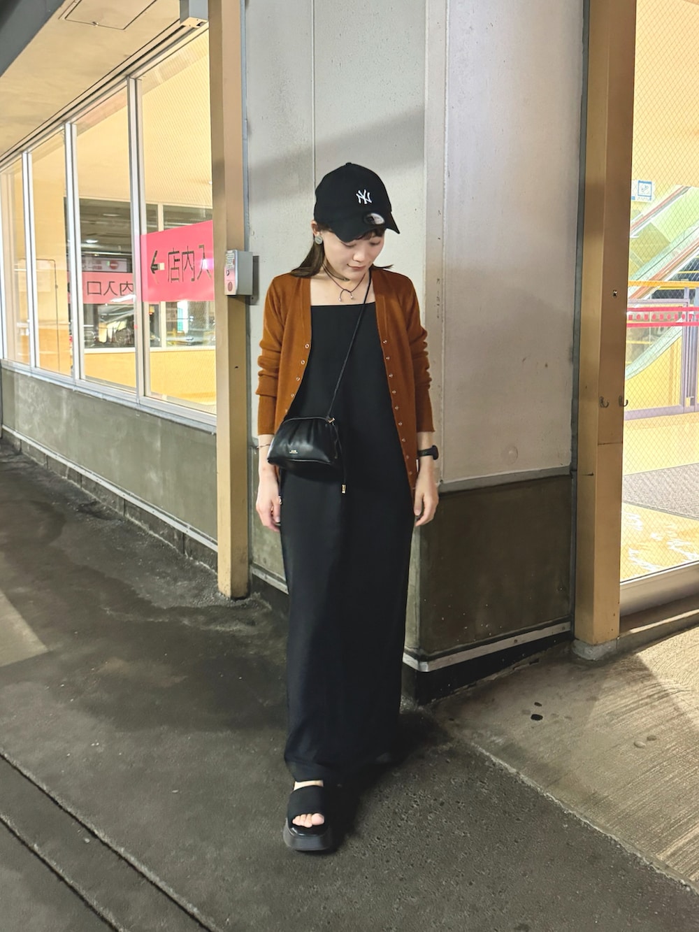 イエロー系のカーディガン/ボレロ、ブラック系のワンピース、ブラック系のショルダーバッグを着用したレディースの夏コーディネートの5枚目の写真