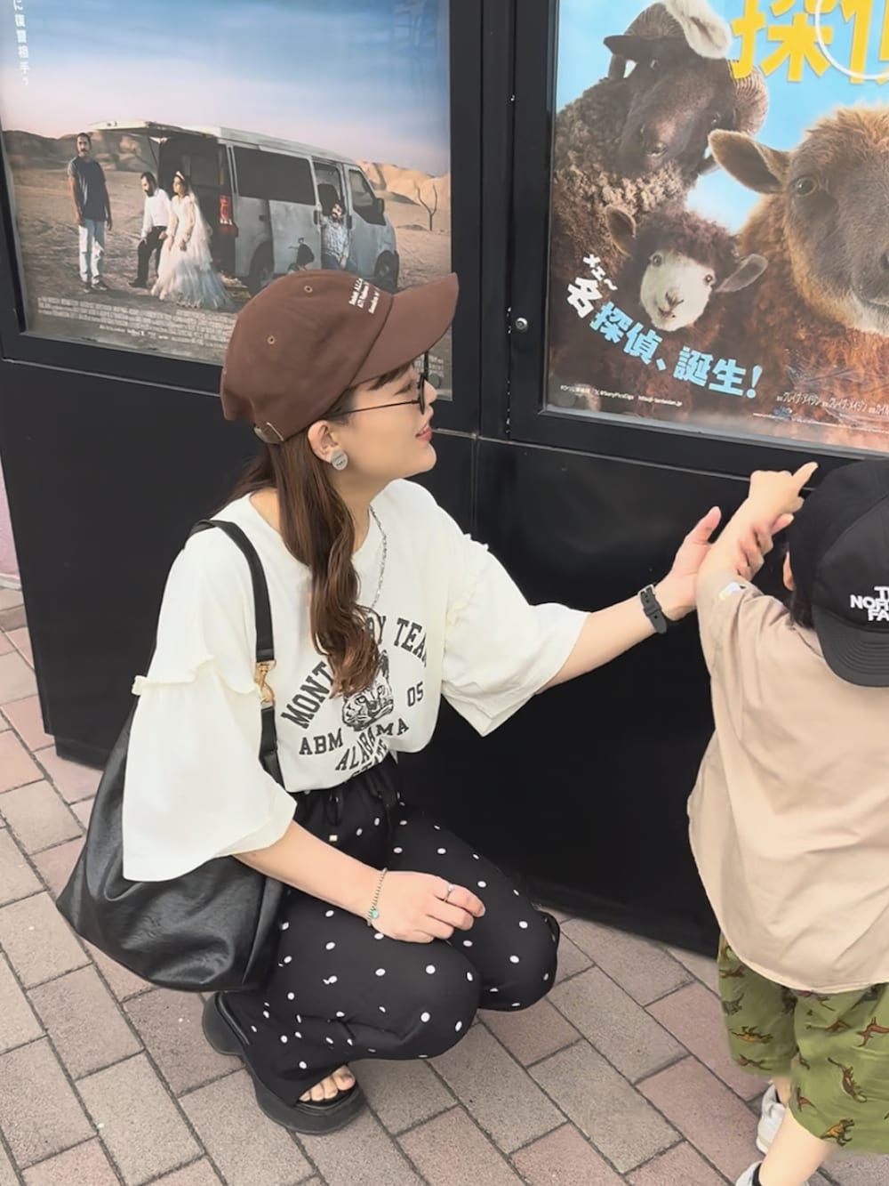 ホワイト系のTシャツ/カットソー、ブラック系のパンツ、ブラック系のバッグを着用したレディースの夏コーディネートの3枚目の写真