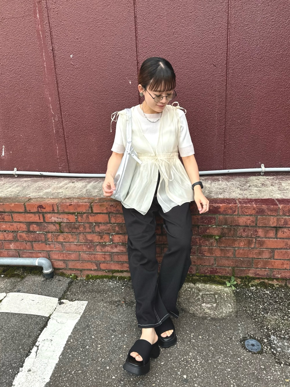 ホワイト系のニット/セーター、ブラック系のデニムパンツ、シルバー系のトートバッグを着用したレディースの夏コーディネートの4枚目の写真