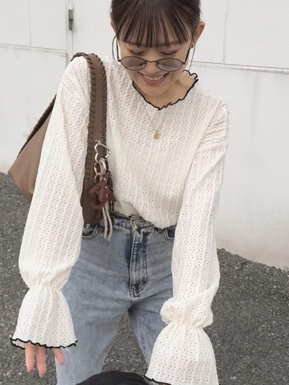 ホワイト系のTシャツ/カットソー、ベージュ系のスニーカー、その他のデニムパンツを着用したレディースの夏コーディネートの4枚目の写真