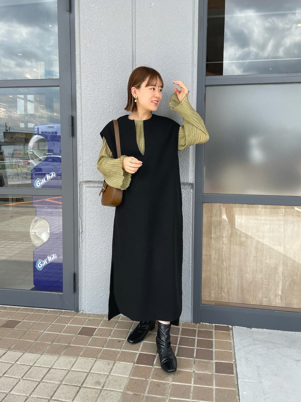 ブラック系のワンピース、グリーン系のシャツ/ブラウス、ブラウン系のバッグを着用したレディースの秋コーディネートの4枚目の写真