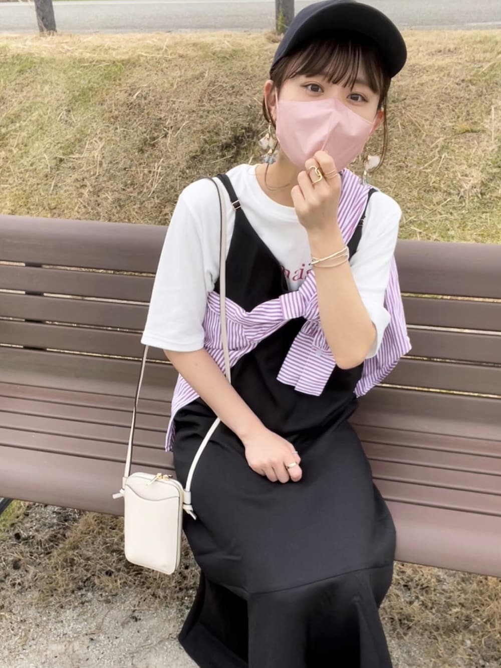 ピンク系のシャツ/ブラウス、ブラック系のジャンパースカート、ホワイト系のバッグを着用したレディースの夏コーディネートの4枚目の写真