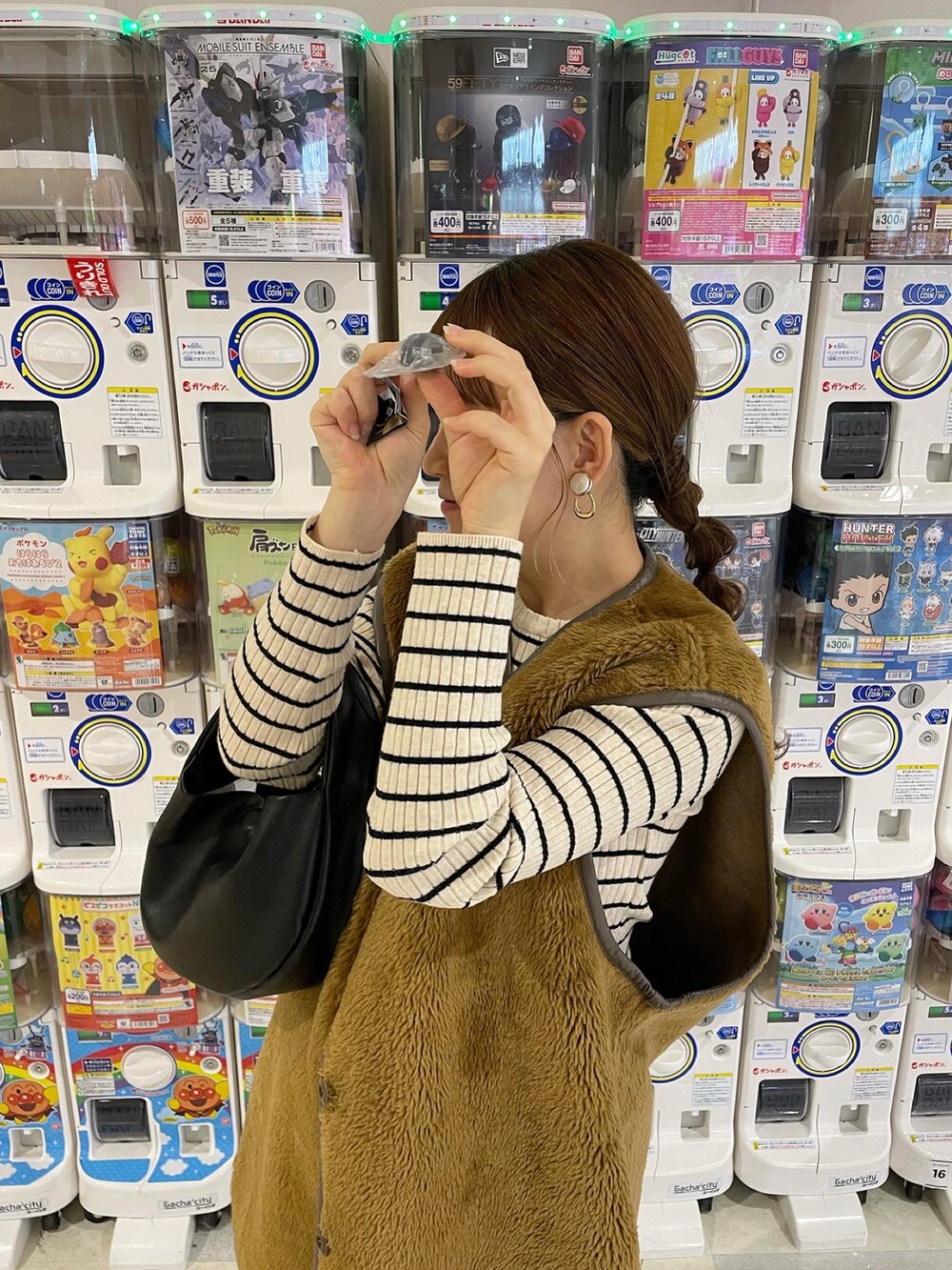 ブラウン系のベスト、ホワイト系のニット/セーター、ブラック系のパンツを着用したレディースの秋コーディネートの4枚目の写真