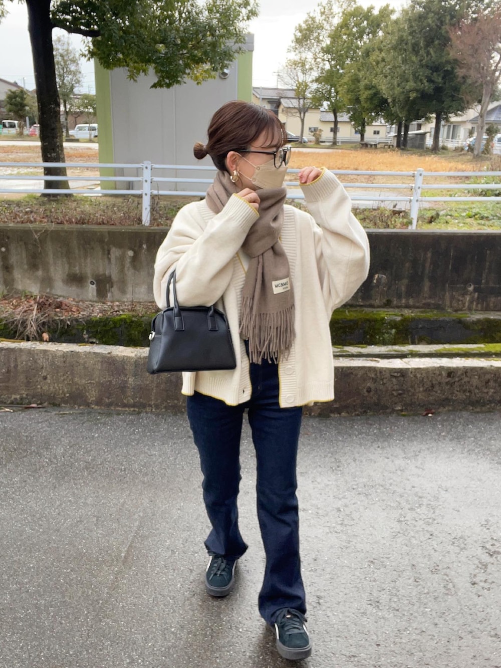 ホワイト系のカーディガン/ボレロ、ホワイト系のニット/セーター、ブルー系のデニムパンツを着用したレディースの冬コーディネートの2枚目の写真