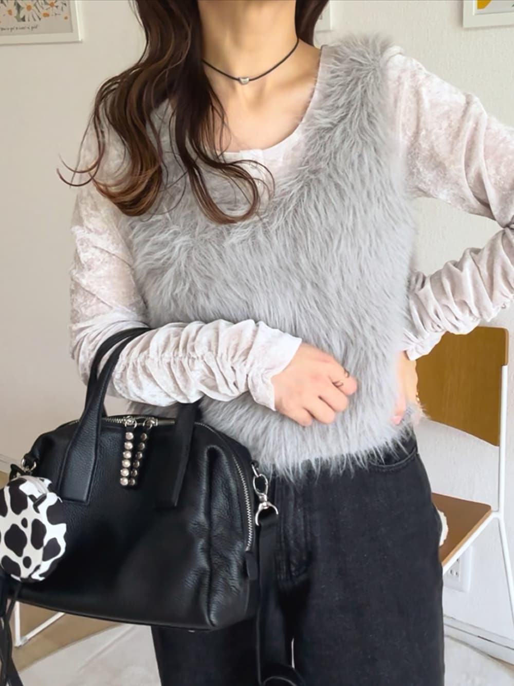 ホワイト系のTシャツ/カットソー、ブラック系のボストンバッグ、グレー系のベストを着用したレディースの秋コーディネートの3枚目の写真