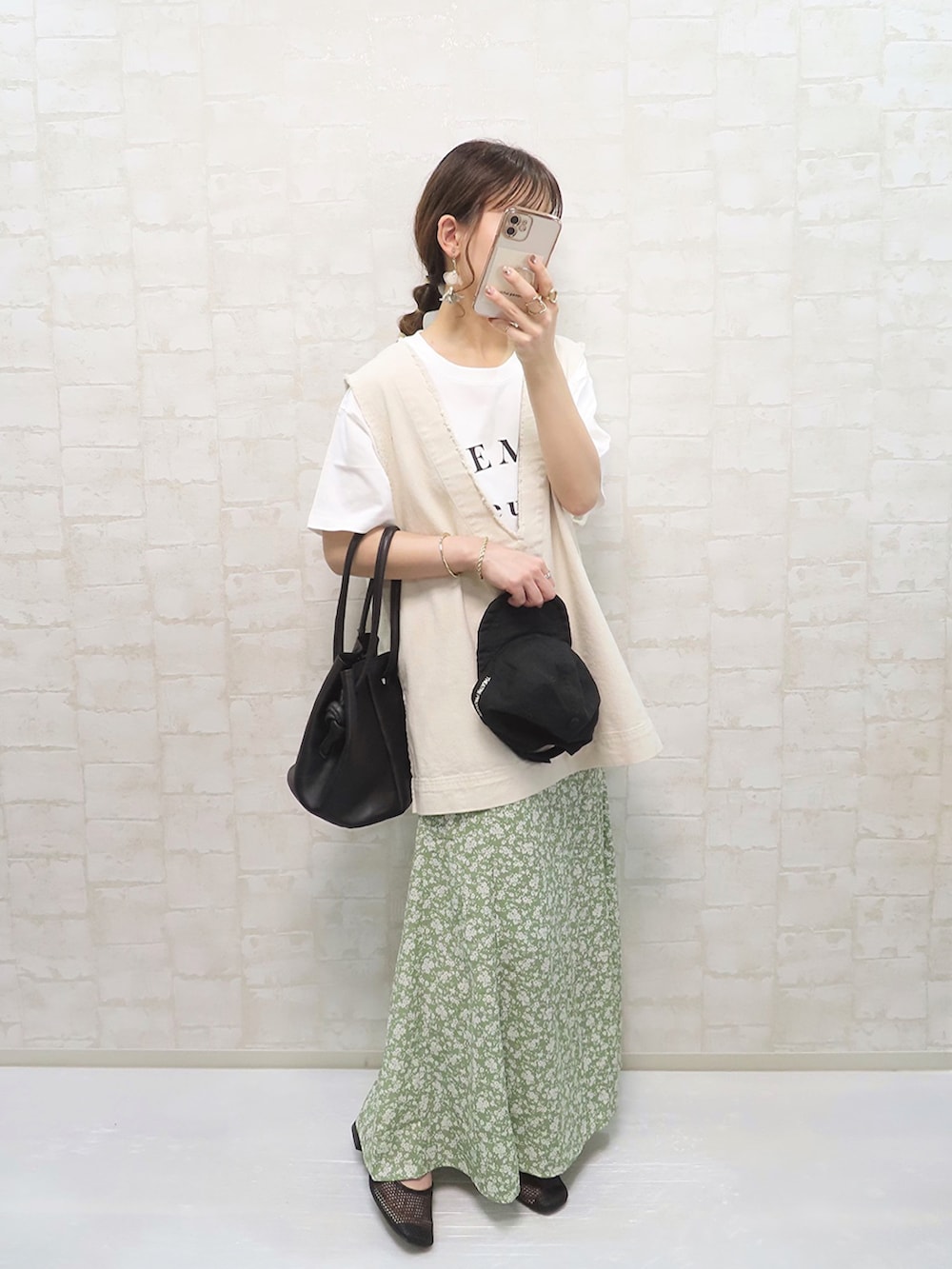 グリーン系のスカート、ホワイト系のTシャツ/カットソー、ホワイト系のベストを着用したレディースの春コーディネートの2枚目の写真