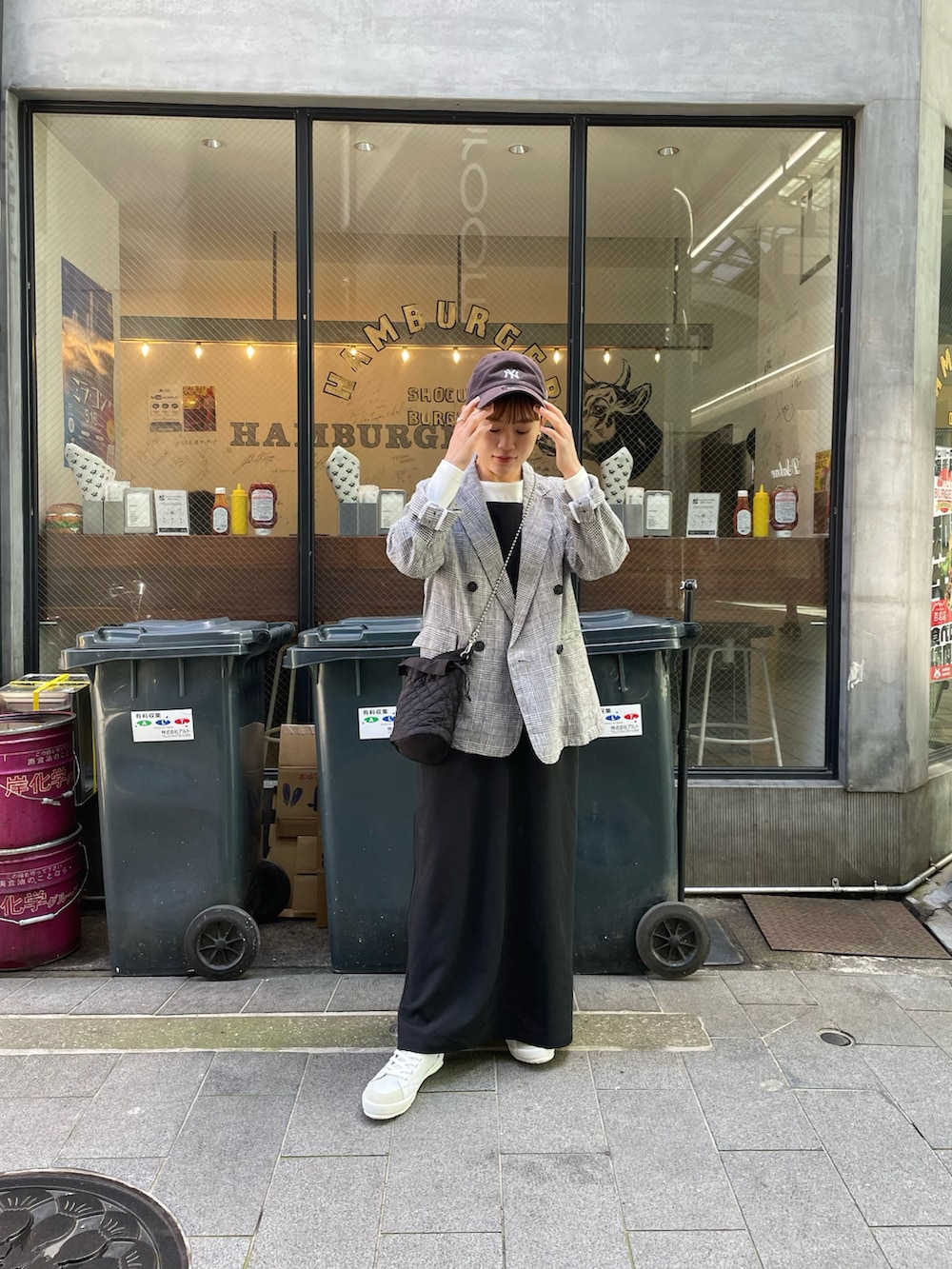 ブラック系のテーラードジャケット、ブラック系のワンピース、ブラック系のショルダーバッグを着用したレディースの春コーディネートの5枚目の写真