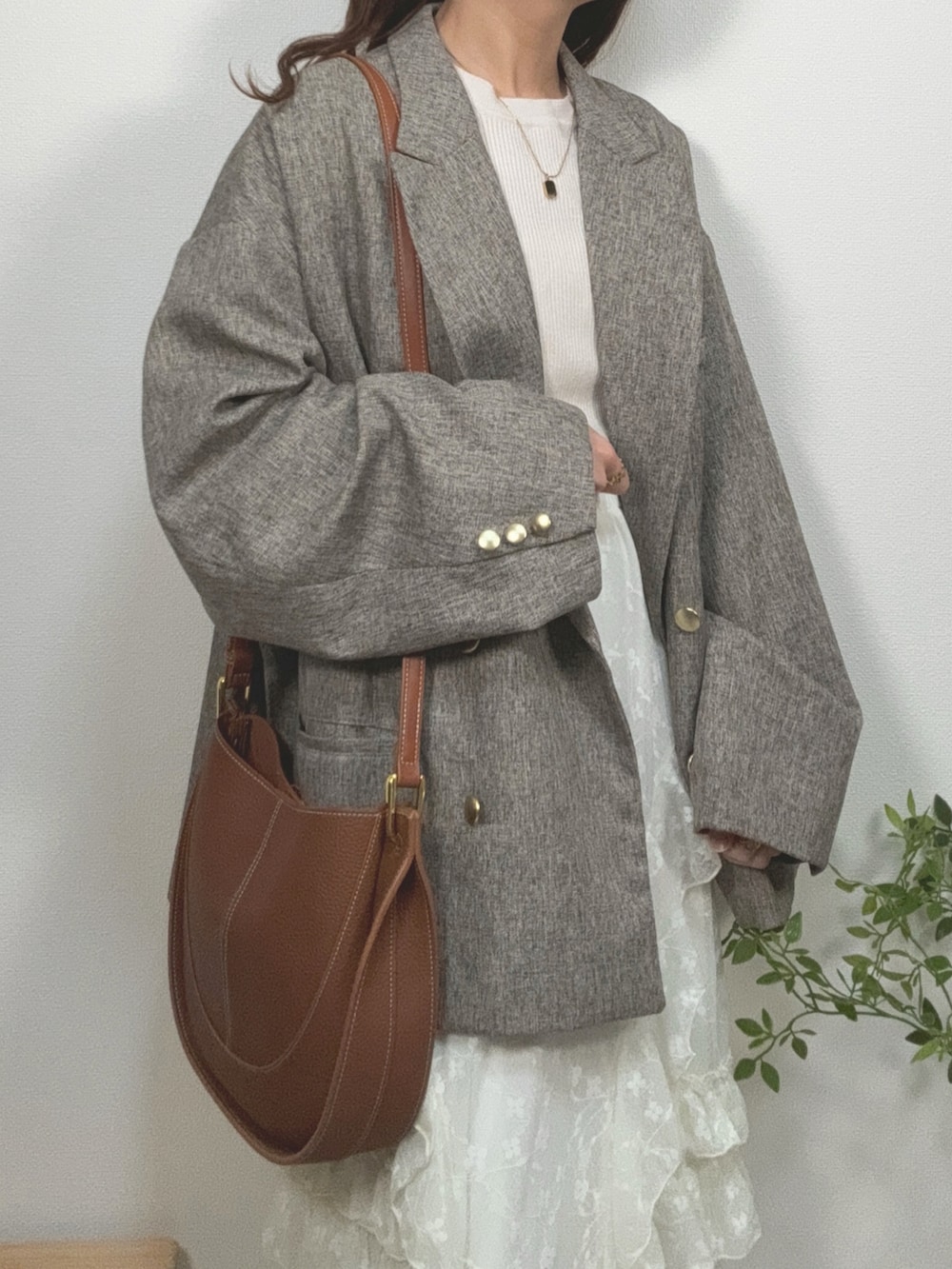 ホワイト系のスカート、ベージュ系のテーラードジャケット、ベージュ系のスニーカーを着用したレディースの春コーディネートの3枚目の写真