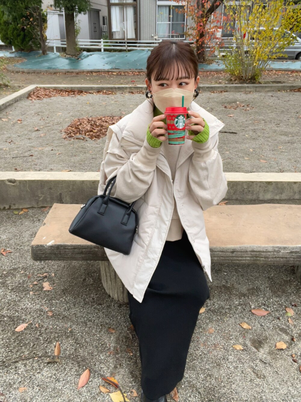 ベージュ系のスウェット、グリーン系のニット/セーター、ホワイト系のダウンベストを着用したレディースの秋コーディネートの5枚目の写真