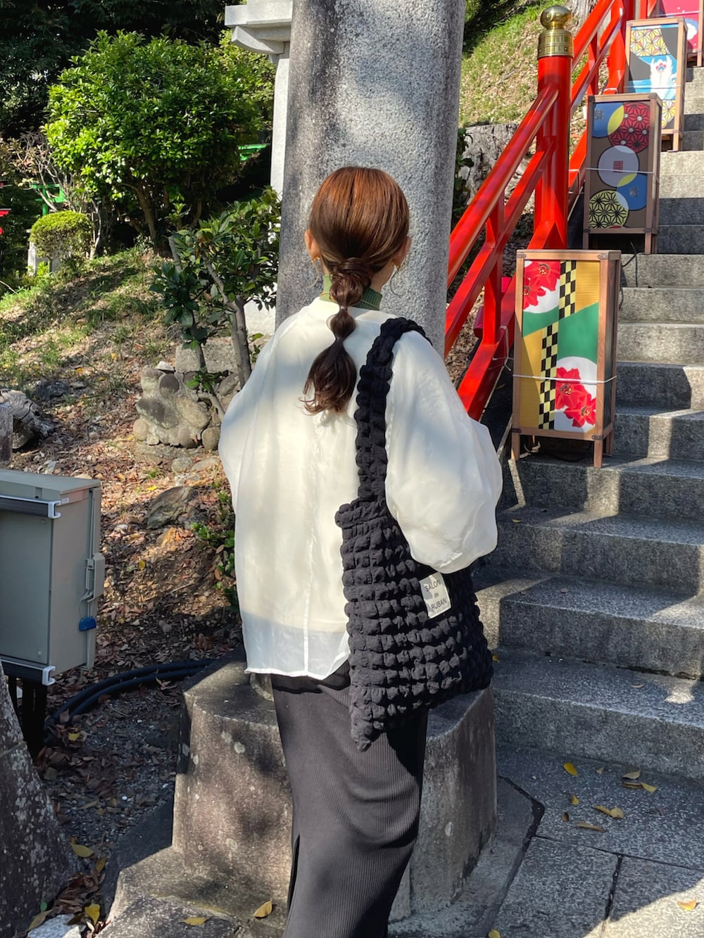 ホワイト系のスウェット、グリーン系のニット/セーター、ブラック系のトートバッグを着用したレディースの秋コーディネートの5枚目の写真