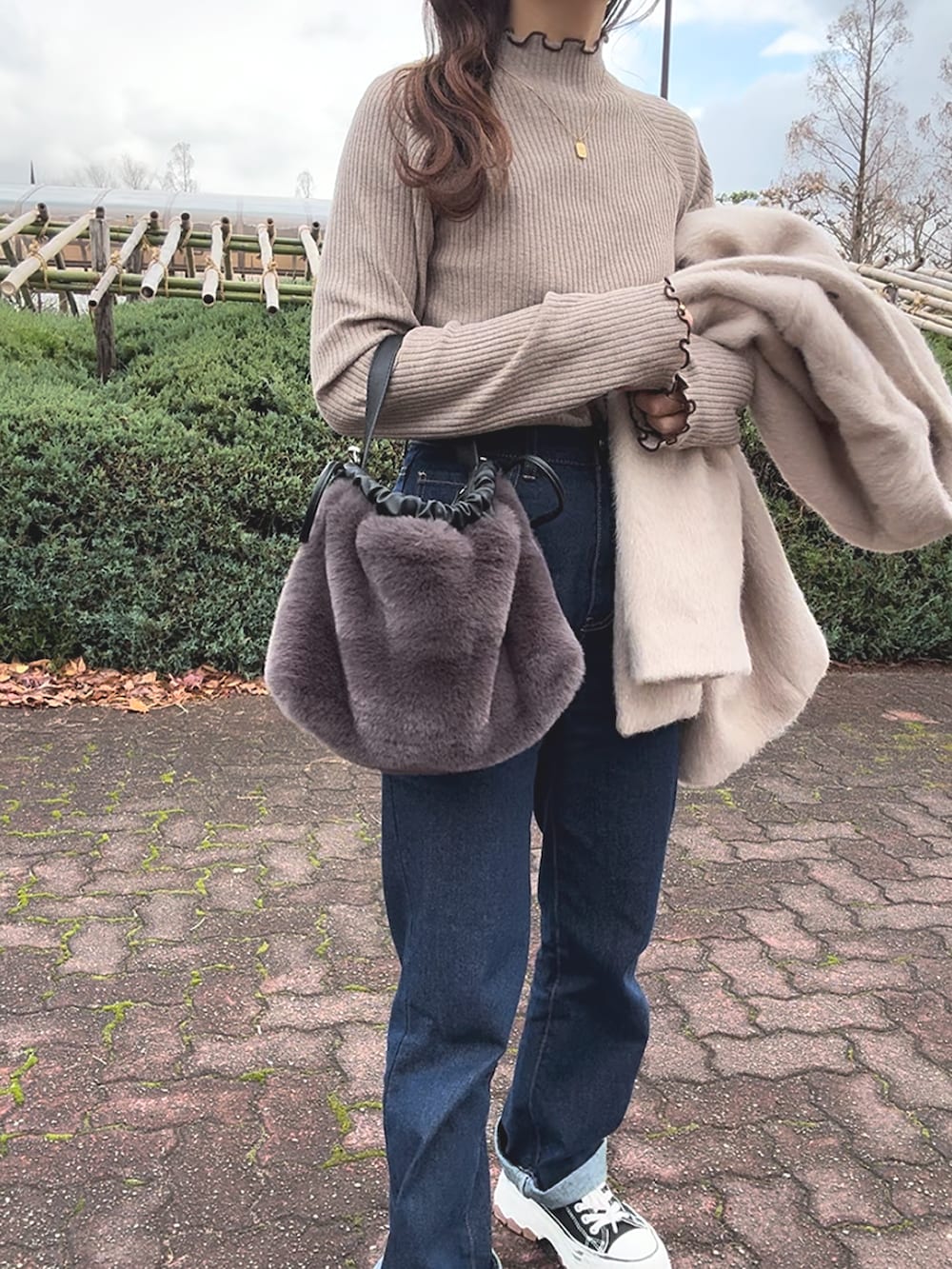 ブラウン系のニット/セーター、ベージュ系のジャケット/アウター、ブルー系のパンツを着用したレディースの冬コーディネートの5枚目の写真