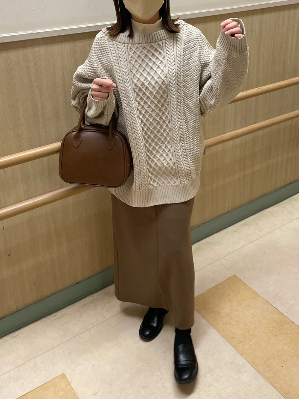 ベージュ系のカーディガン/ボレロ、ブラウン系のスカート、ブラウン系のショルダーバッグを着用したレディースの冬コーディネートの3枚目の写真