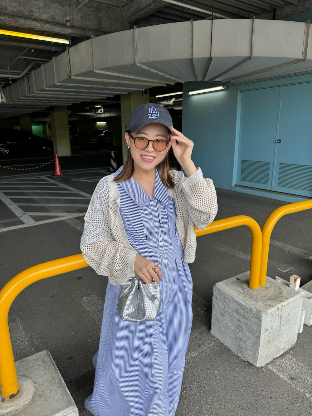 ブルー系のワンピース、ホワイト系のカーディガン/ボレロ、シルバー系のバッグを着用したレディースの春コーディネートの5枚目の写真