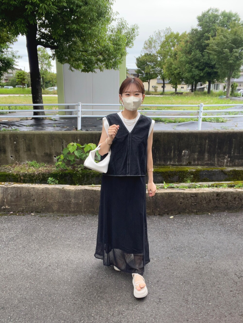 ブラック系のベスト、ホワイト系のニット/セーター、ブラック系のワンピースを着用したレディースの夏コーディネートの4枚目の写真
