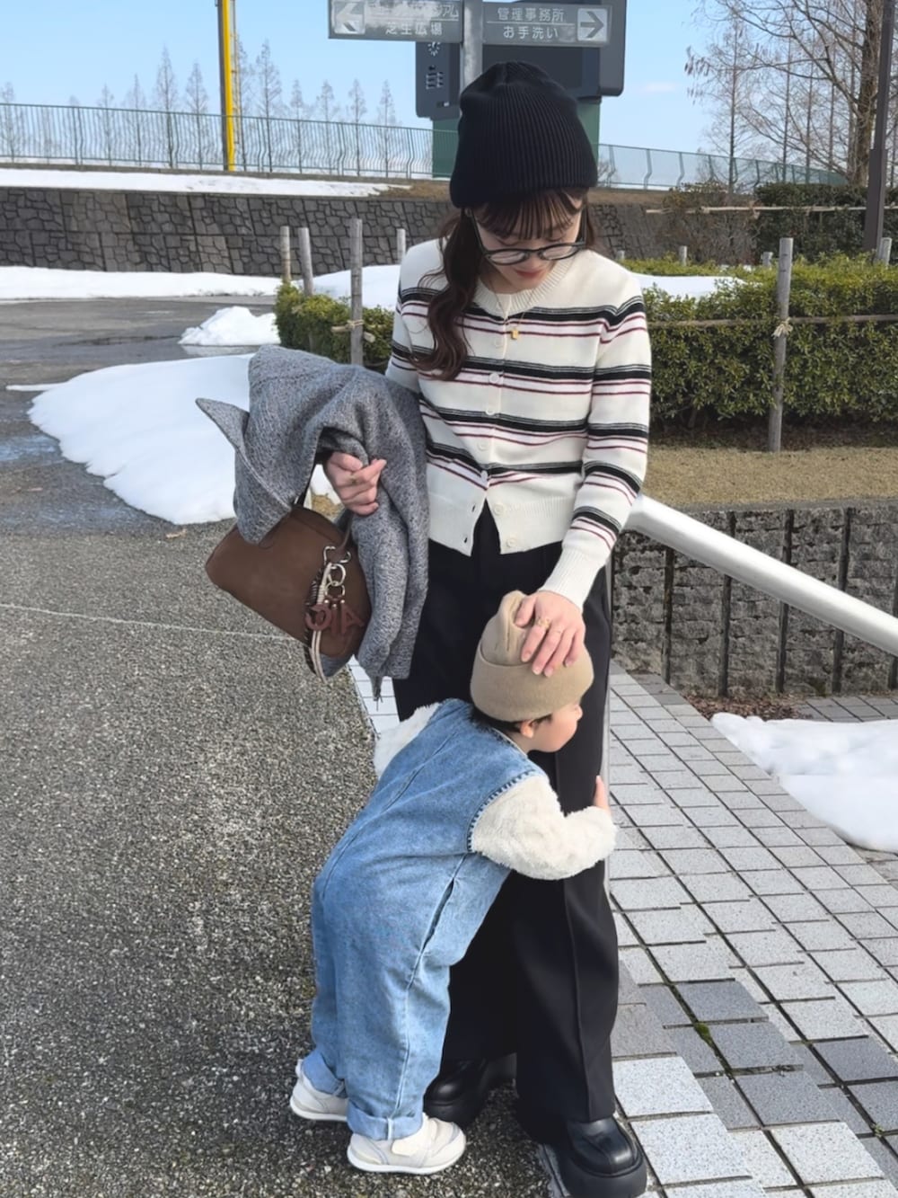 ホワイト系のカーディガン/ボレロ、ブラック系のパンツ、ブラウン系のバッグを着用したレディースの春コーディネートの3枚目の写真