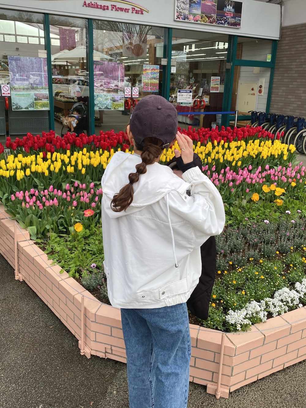 ホワイト系のマウンテンパーカー、ブルー系のデニムパンツ、グレー系のスウェットを着用したレディースの春コーディネートの3枚目の写真