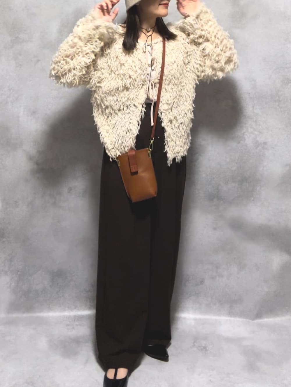ホワイト系のカーディガン/ボレロ、ブラウン系のパンツ、ブラウン系のショルダーバッグを着用したレディースの秋コーディネートの2枚目の写真