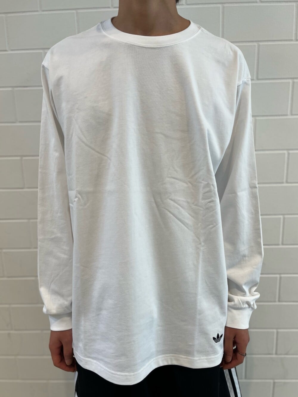 ブラック系のスニーカー、ホワイト系のTシャツ/カットソー、ブラック系のその他パンツを着用したメンズの夏コーディネートの4枚目の写真
