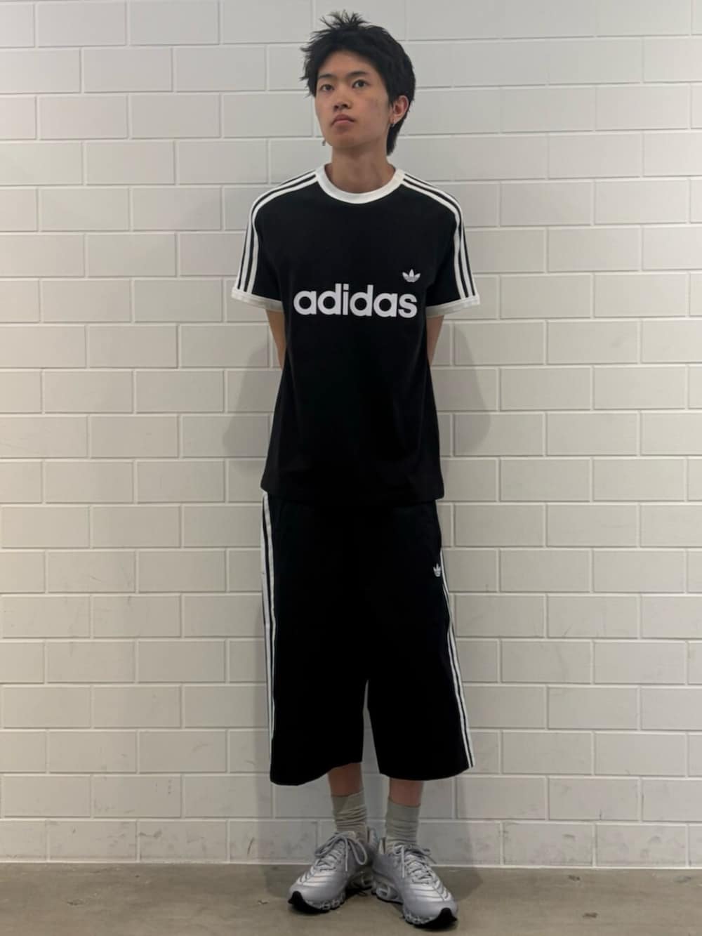 シルバー系のスニーカー、ブラック系のTシャツ/カットソー、ブラック系のその他パンツを着用したメンズの夏コーディネートの3枚目の写真