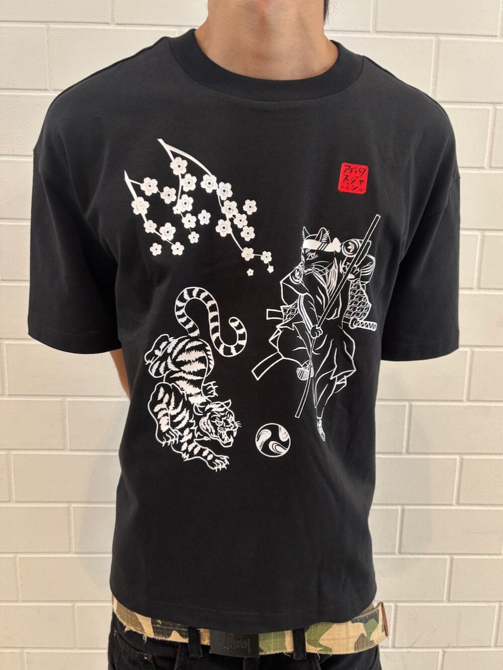 ブラック系のトップス、ブラック系のスニーカー、ブラック系のキャップを着用したメンズの夏コーディネートの3枚目の写真