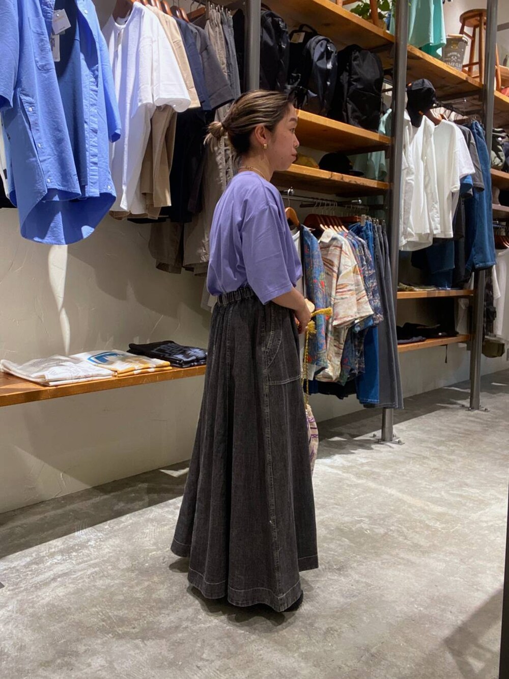 パープル系のショルダーバッグ、パープル系のTシャツ/カットソー、グレー系のスカートを着用したレディースの夏コーディネートの2枚目の写真