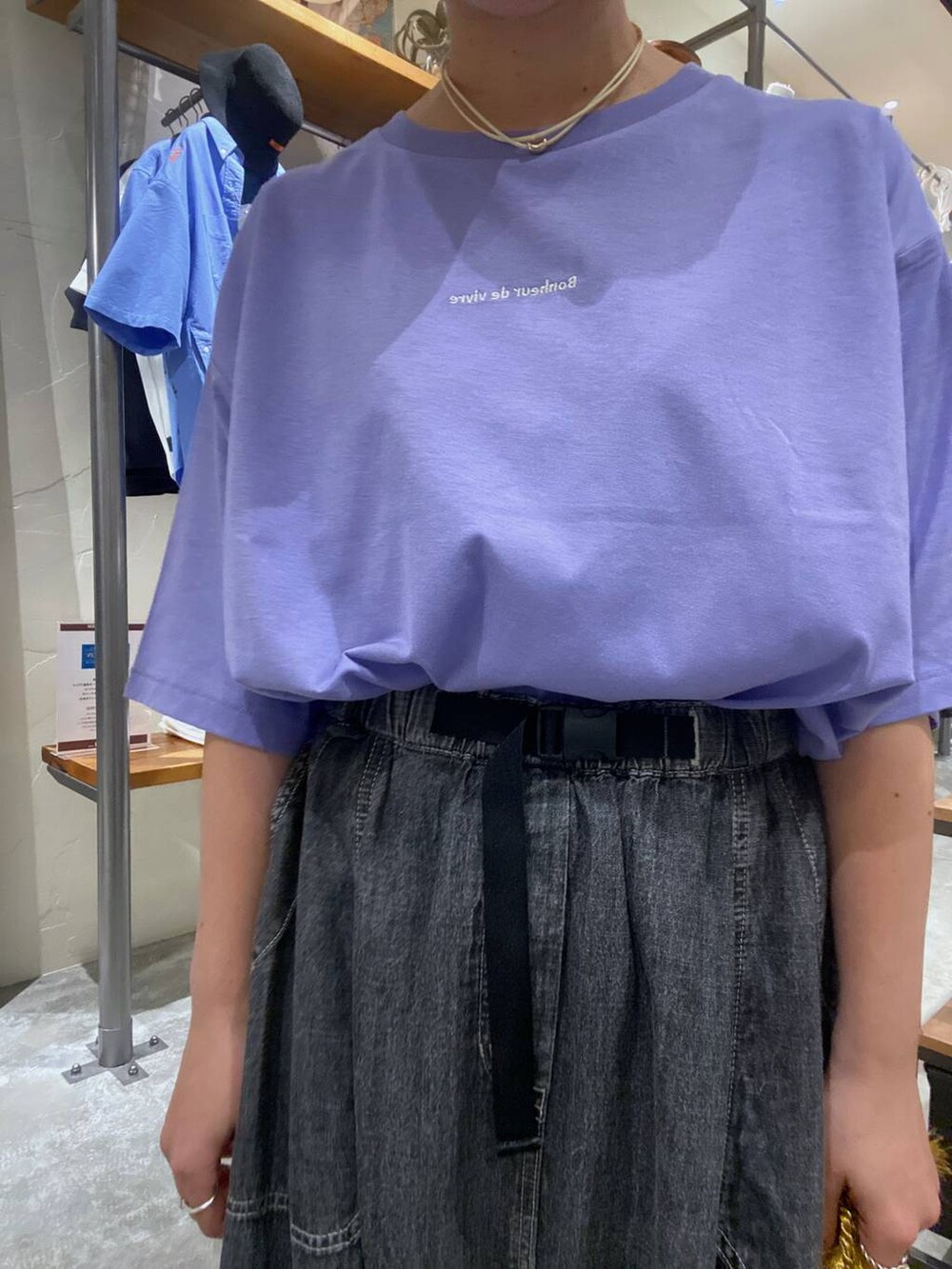 パープル系のショルダーバッグ、パープル系のTシャツ/カットソー、グレー系のスカートを着用したレディースの夏コーディネートの4枚目の写真