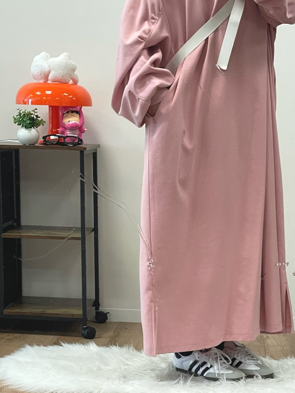 ピンク系のワンピース、ホワイト系のボディバッグ/ウエストポーチ、ホワイト系のスニーカーを着用したレディースの冬コーディネートの2枚目の写真