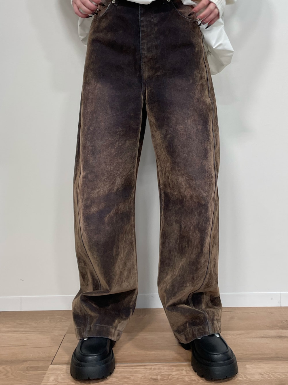 グレー系のスウェット、ブラウン系のデニムパンツ、ブラック系のバッグを着用したレディースの秋コーディネートの2枚目の写真